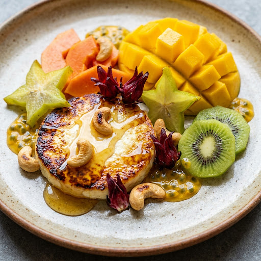 Fruit-forward plated dessert with mango, kiwi, and starfruit.